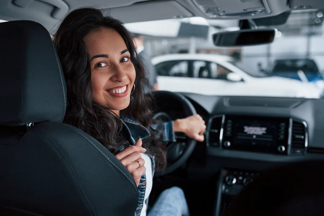 Consultora da Lia ao lado de um carro de luxo